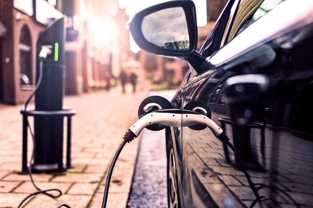 An electric vehicle plugged in at a recharging station.